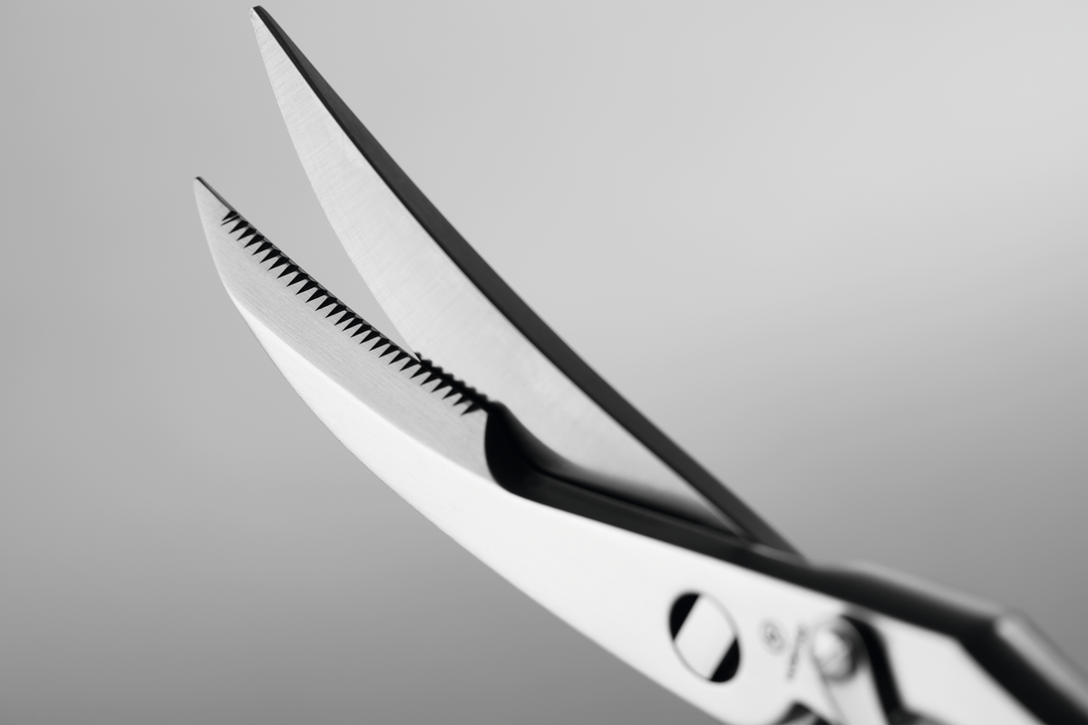9" Stainless Steel Poultry Shears detailed close-up showcasing sharp, serrated curved blades and a durable stainless steel hinge for precision cutting.