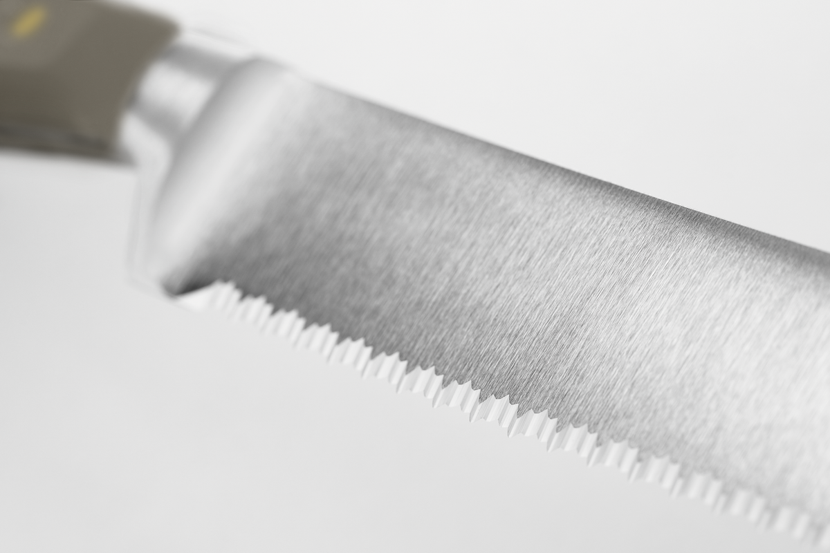 Classic 9" Precision Double-Serrated Bread Knife close-up showing the finely crafted serrated stainless steel blade with a smooth edge for clean slicing.