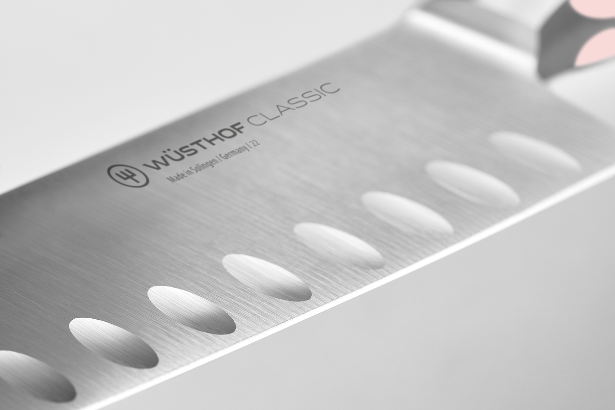 Classic 7" Hollow Edge Santoku featuring forged German steel blade with scalloped hollow edges to reduce food sticking for smooth, precise cutting.