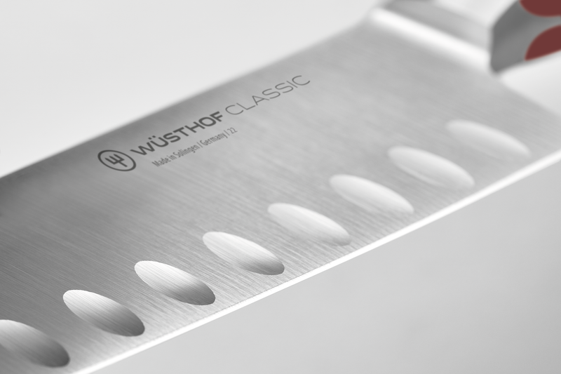 Classic 7" Hollow Edge Santoku featuring a polished German steel blade with scalloped hollow edges to prevent food from sticking during chopping.