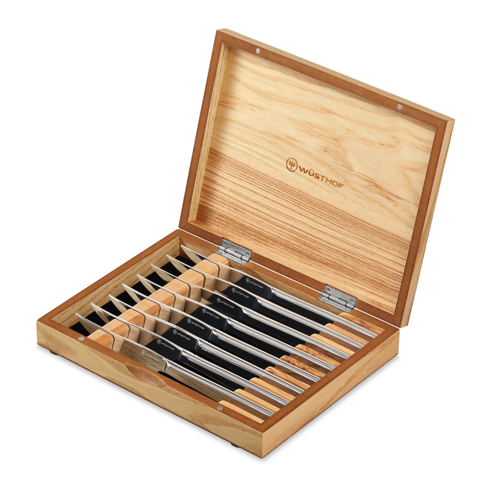 8-Piece Stainless Mignon Steak Knife Set with sharp stainless steel blades and polished handles, presented in a natural wood storage box with the WÜSTHOF logo.