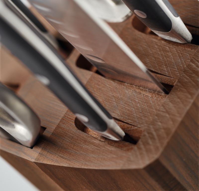 Close-up of knives with metal rivets and black handles inserted into slots of the 8-Slot Heat Treated Beech Knife Block showing fine wood texture and precision craftsmanship.