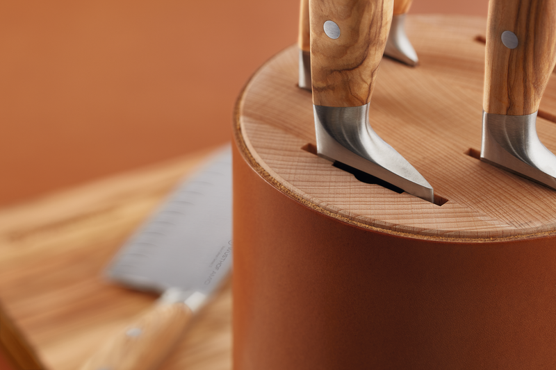 Villa 6-Slot Knife Block featuring tan leather exterior with detailed stitching and a close-up of wooden-handled forged kitchen knives inserted securely.