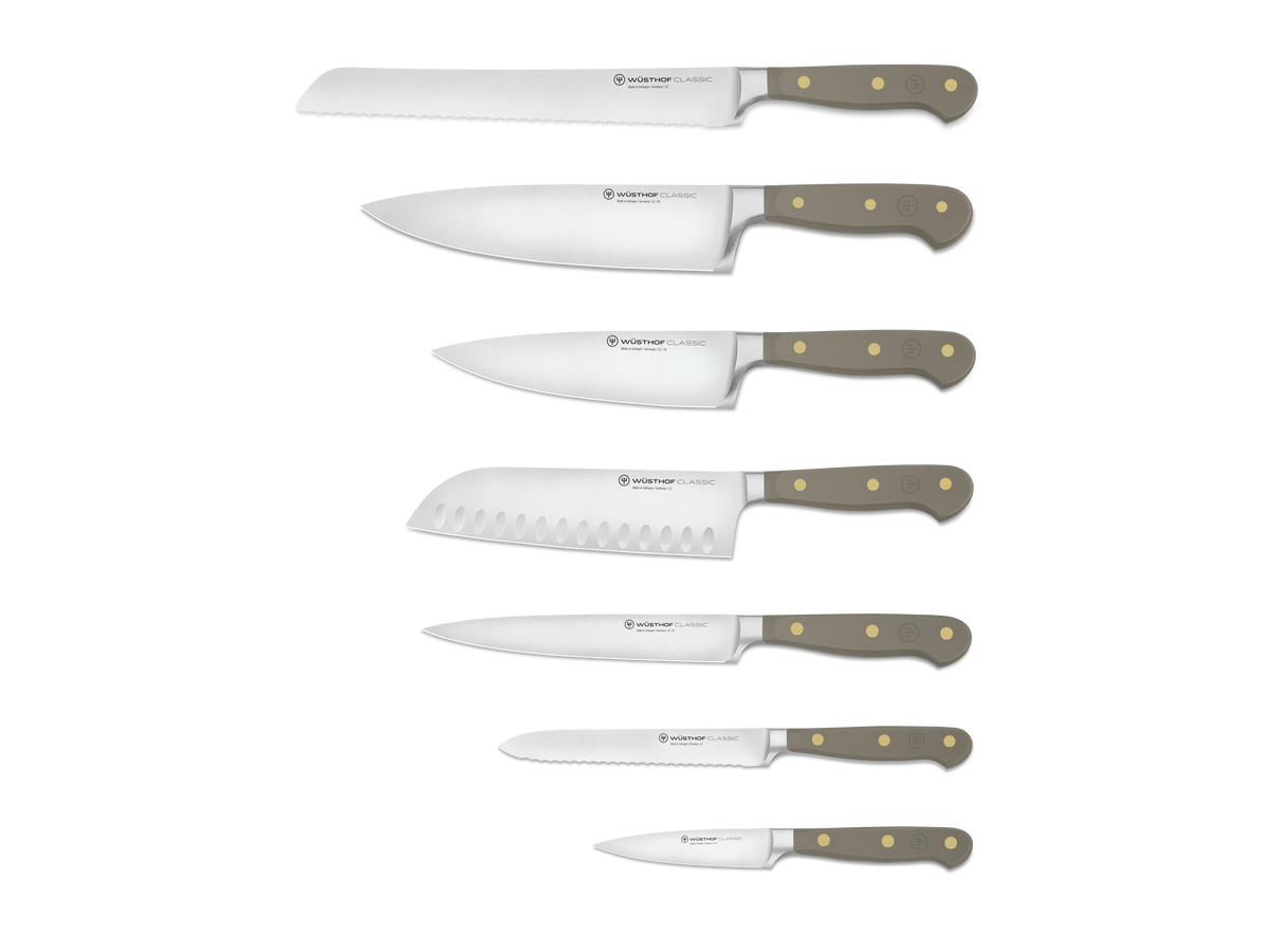 Classic 8-Piece Designer Knife Block Set featuring six forged German steel knives with smooth taupe ergonomic handles and brass rivets, including serrated and chef’s knives.