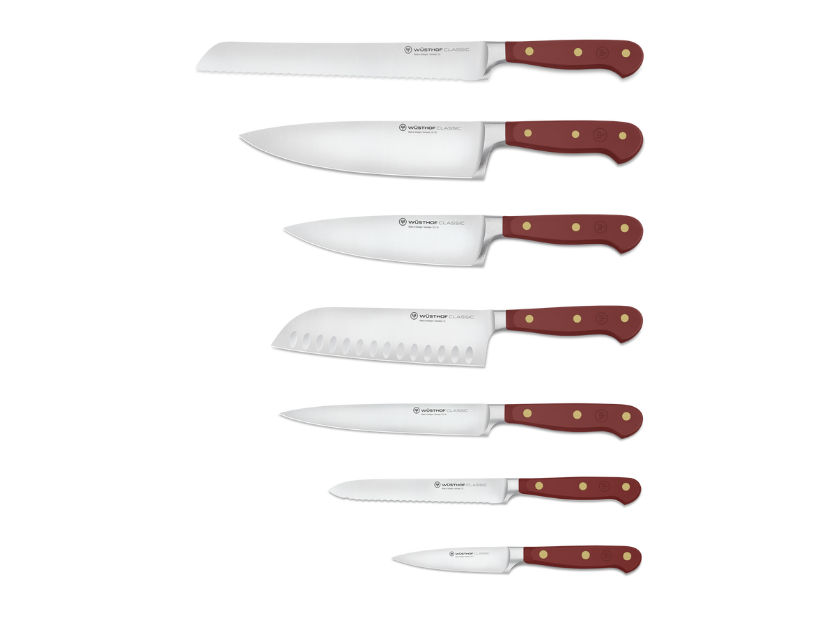 Classic 8-Piece Designer Knife Block Set displaying six forged German steel knives with rich red ergonomic handles and brass rivets, ideal for chefs.