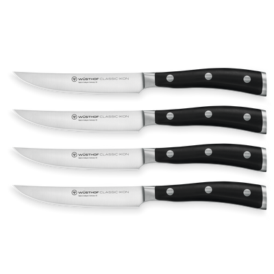 Classic Ikon 4-Piece Steak Knife Set with forged German steel blades and triple-riveted black ergonomic handles for precise and comfortable cutting.