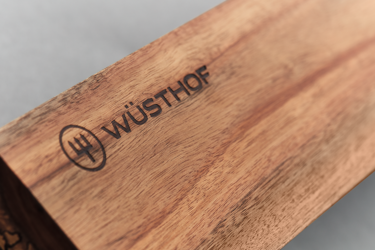 Close-up of natural wood grain with engraved WÜSTHOF logo on the 12" Wooden Magnetic Holder for stylish and secure knife storage.