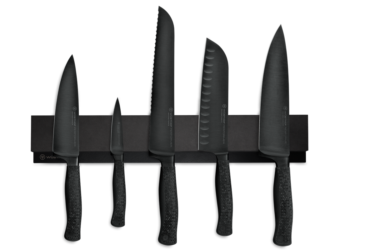 16" Magnetic Holder secures a set of black forged kitchen knives with textured handles, showcasing precision and modern design.