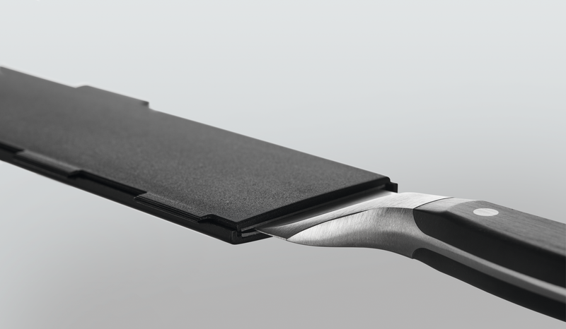 Wide Magnetic Blade Guard protecting the blade of a forged kitchen knife with a polished black handle and metal rivets for safe storage.