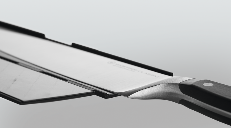 Wide Magnetic Blade Guard in black securely protecting the blade of a forged German kitchen knife with a polished handle and rivets for safe storage.