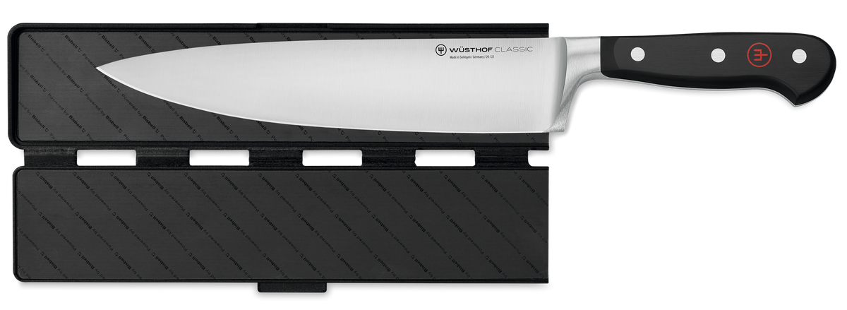 Wide Magnetic Blade Guard securely protecting the blade of a forged German kitchen knife with a polished black handle and rivets.