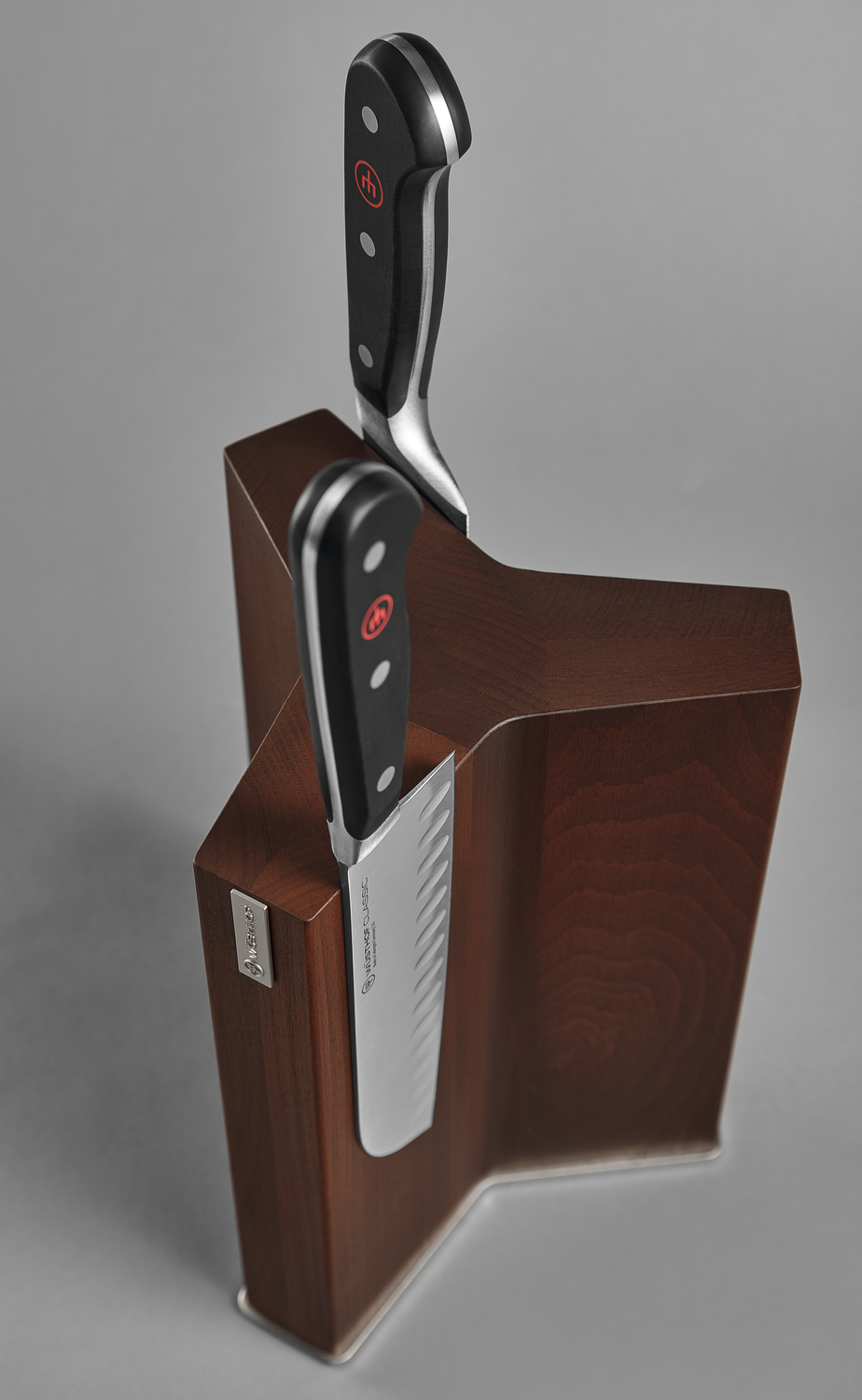 Magnetic Knife Block in dark wood with a modern angular design, holding two knives with black ergonomic handles and polished blades for secure storage.
