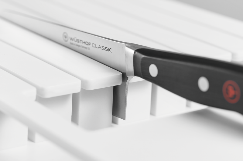 7-Slot In-Drawer Knife Organizer made from white plastic holding a WÜSTHOF Classic knife with a sharp forged blade and a black handle with rivets.