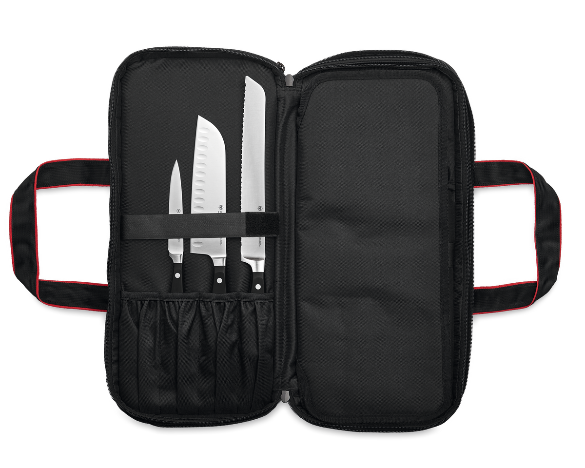 20-Slot Knife Case open to reveal black fabric interior with elastic loops and compartments, holding three German forged kitchen knives securely.