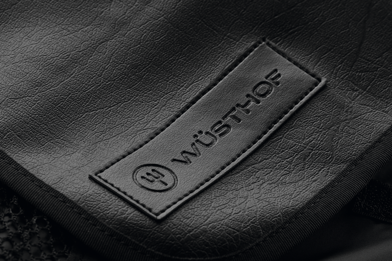 Close-up of the textured black Nylon Knife Roll featuring an embossed WÜSTHOF logo patch sewn onto the durable fabric surface.