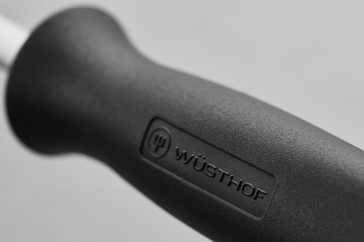 Close-up of the textured black handle on the 9" Honing Steel, featuring an embossed WÜSTHOF logo for secure grip and precise sharpening.