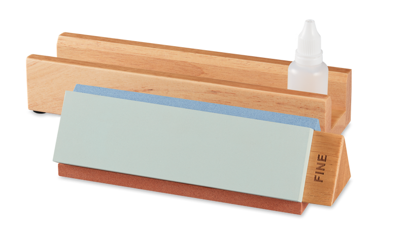 Tri-Stone Knife Sharpener featuring a wooden base with detachable fine and medium grit sharpening stones and a small bottle of honing oil for precise knife edge maintenance.
