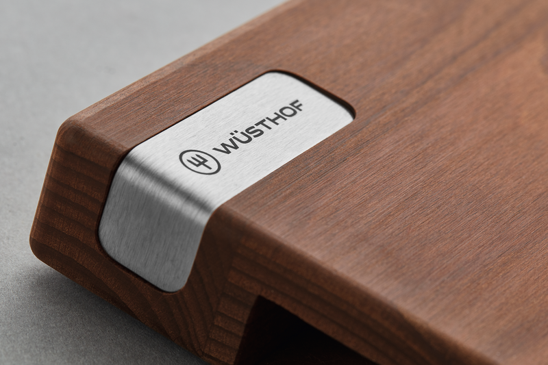 Heat-Treated Beech Cutting Board featuring a smooth wood surface with a stainless steel corner accent engraved with the WÜSTHOF logo for elegant kitchen use.