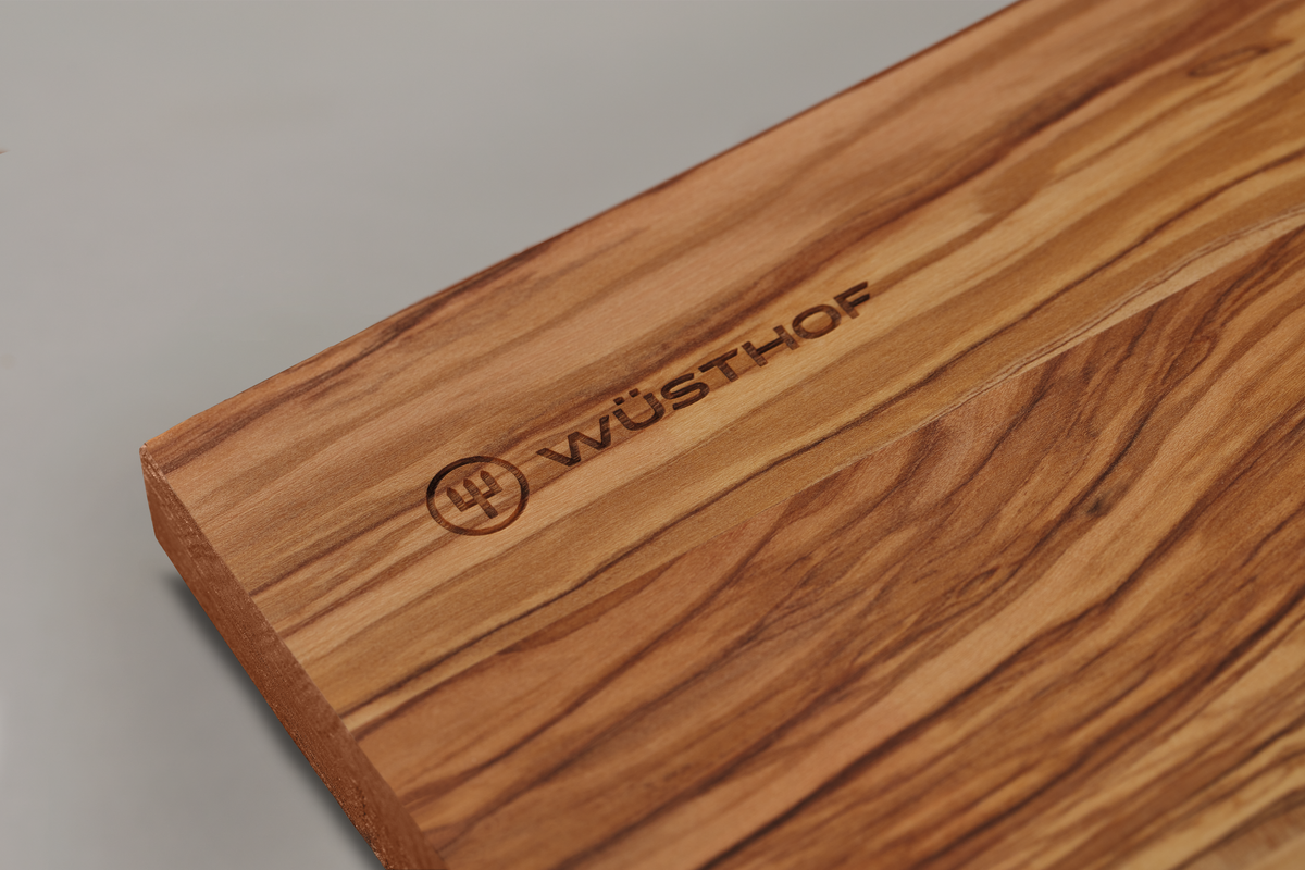 Dune Cutting Board made from richly grained natural wood with a smooth edge, featuring a subtle WÜSTHOF logo engraving.