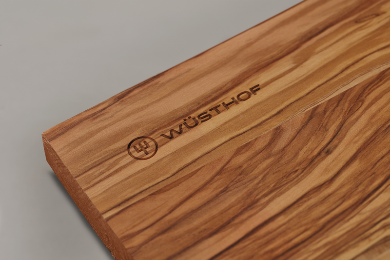 Dune Cutting Board made from richly grained natural wood with a smooth edge, featuring a subtle WÜSTHOF logo engraving.