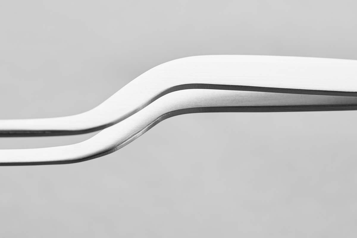 Gourmet Tweezers feature a sleek stainless steel design with a gentle curve for enhanced precision and control in detailed kitchen tasks.