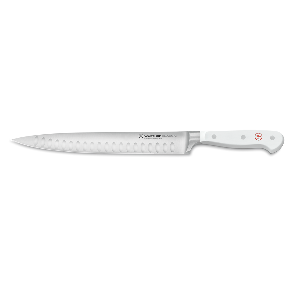 Classic 9" Hollow Edge Carving Knife with a forged German steel blade featuring scalloped indentations and a white ergonomic handle with rivets.
