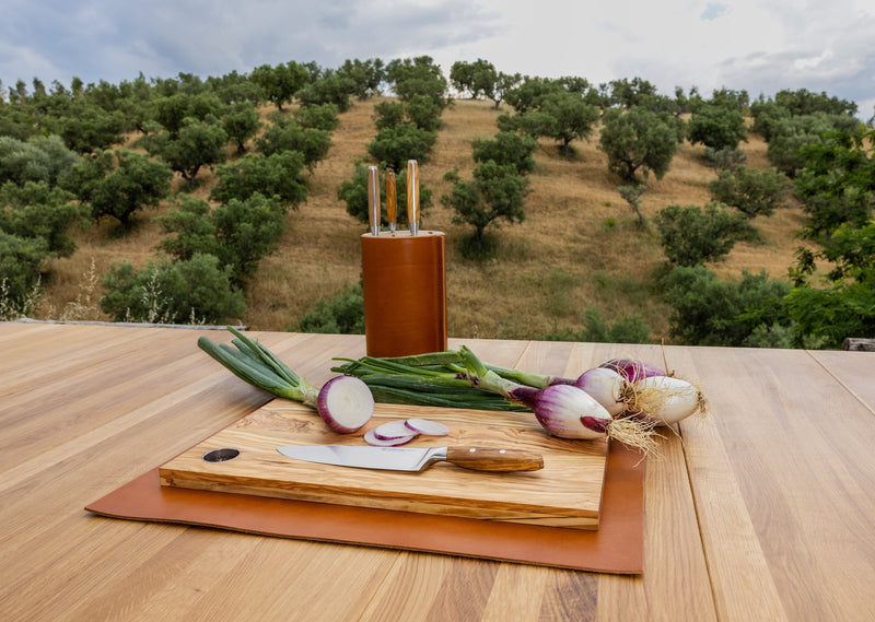 Villa 6-Piece Knife Block Set displayed outdoors on a wooden table with fresh onions and scallions, featuring natural wood handles and forged blades.