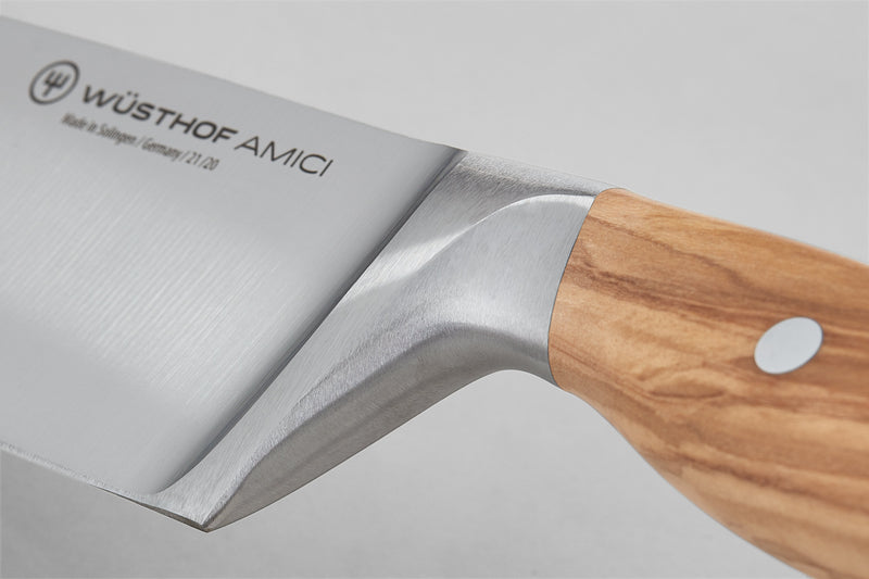 Close-up of the "Amici 6" Chef's Knife showing the forged stainless steel blade with a smooth bolster and a light wooden handle with a metal rivet.