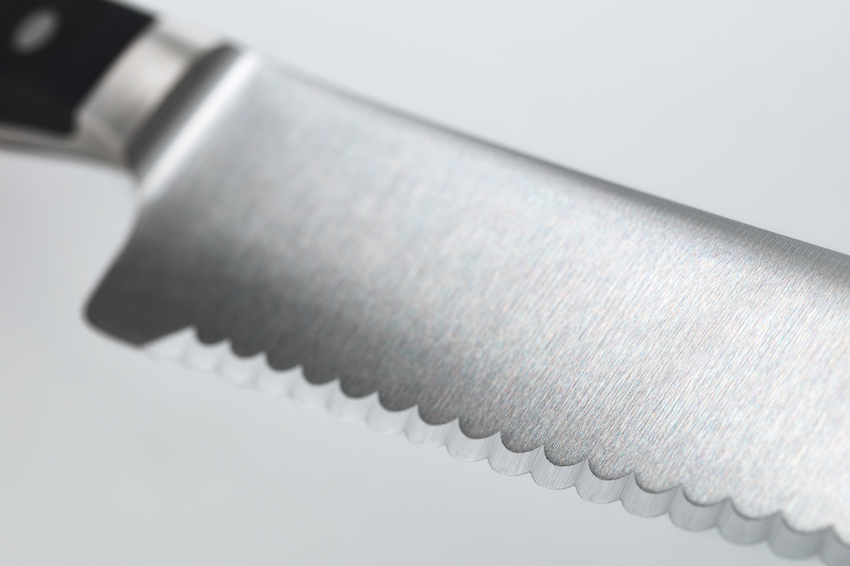Close-up of the serrated forged German steel blade on the Classic 10" Super Slicer emphasizing its precision cutting edge and durability.