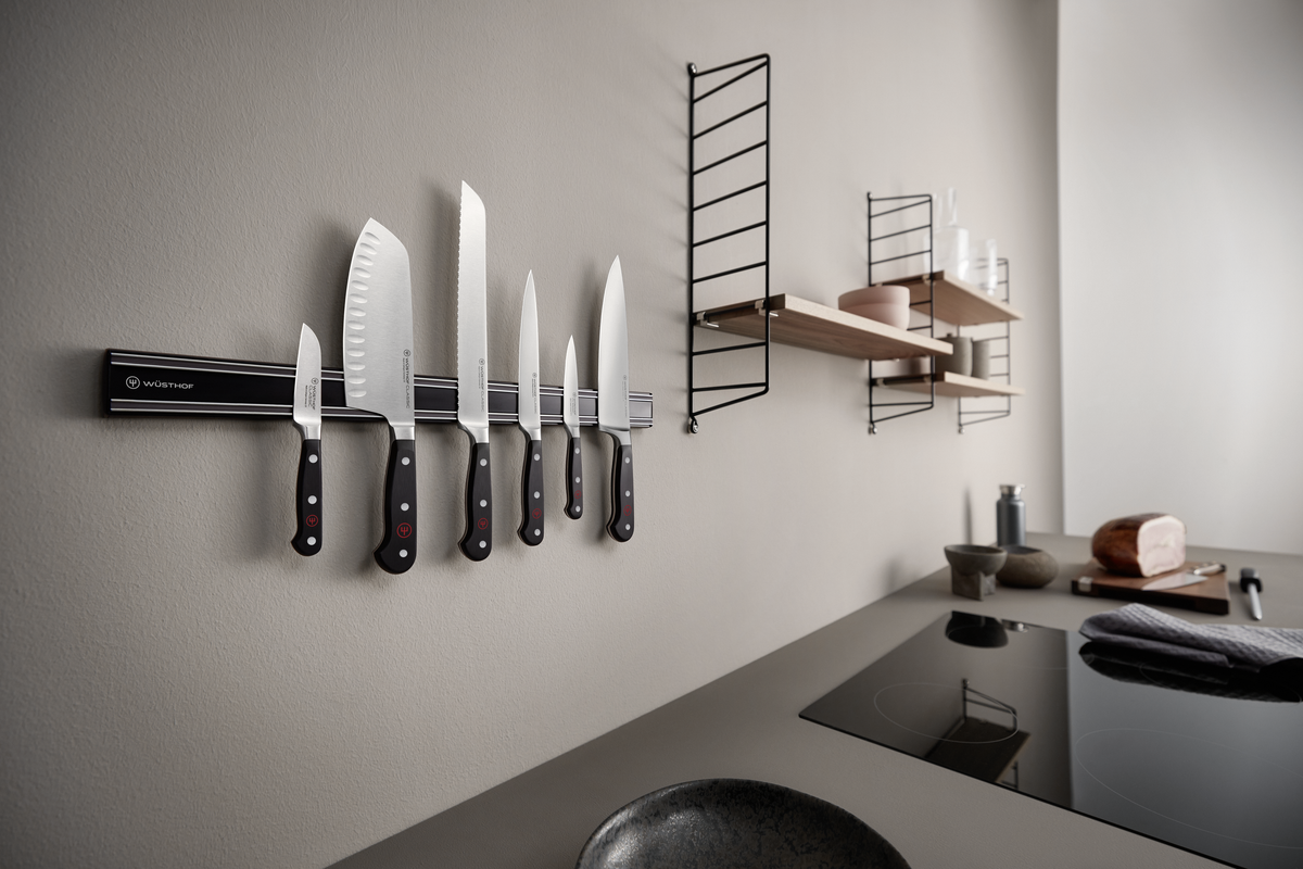 20" Magnetic Holder in matte black with steel rails mounted on a kitchen wall, holding six forged kitchen knives including chefs knives.
