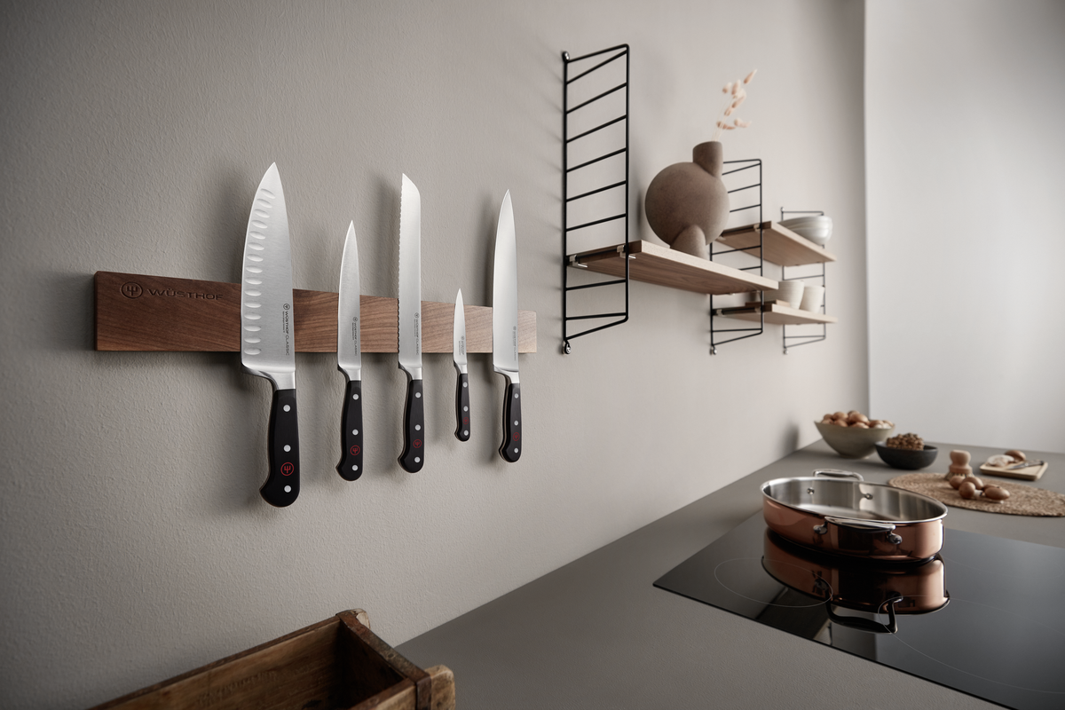 18" Magnetic Holder mounted on a neutral kitchen wall displaying five WÜSTHOF forged kitchen knives with black handles and visible rivets.
