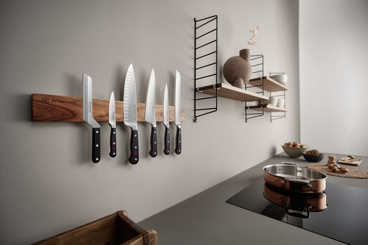20" Magnetic Holder in rich walnut wood with engraved logo, mounted on kitchen wall holding six forged WÜSTHOF chefs knives.