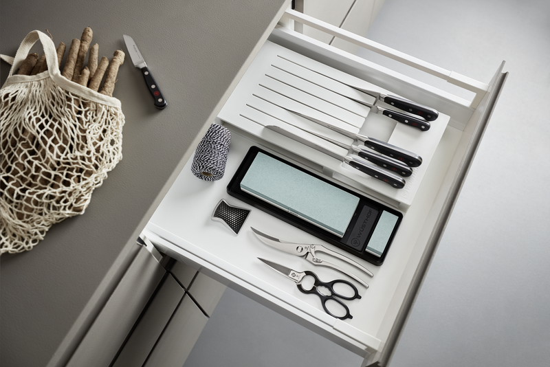 Stainless Kitchen Shears with Synthetic Grips alongside kitchen knives, a sharpening stone, and a sharpening steel in an organized drawer setting.